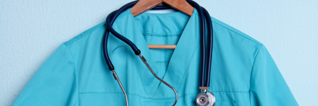 Scrub top on a hanger with a stethoscope draped around it