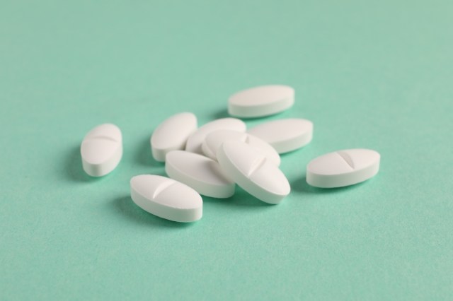 White pills on a light green background