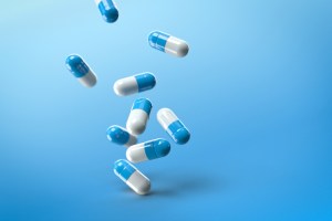 Blue and white capsule pills with a blue background