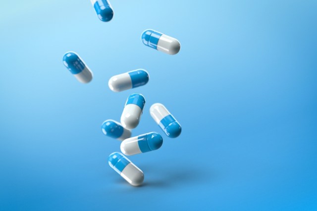 Blue and white capsule pills with a blue background