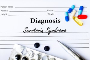 Serotonin Syndrome - Diagnosis written on a piece of white paper with medication and Pills