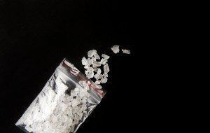 Conceptual image of "bath salts" synthetic cathinones drugs narcotics concept. White crystal powder on black background( set up), resemble to bathroom bath salt.