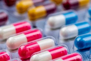 Colorful antibiotic capsule pills in blister pack. Pharmaceutical industry. Pharmacy drugstore background.