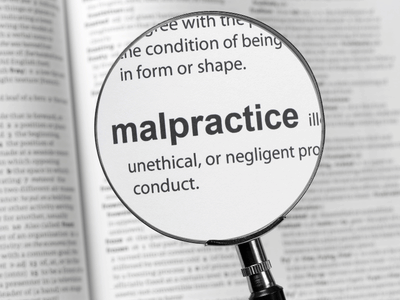 Malpractice definition with magnifying glass